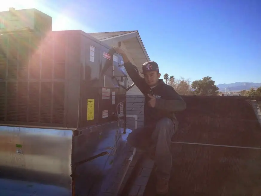 HVAC technician performing Air Duct Cleaning on a rooftop unit in Nyack